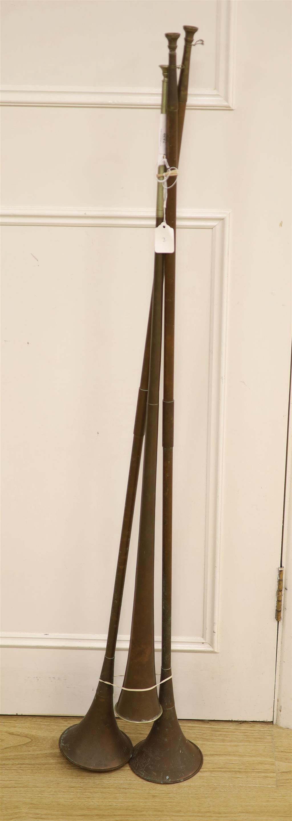A 19th century copper coaching horn with nickel mounts, and two others, max 121cms.